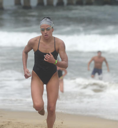 07-31-2011--(Staff Photo by Sean Hiller)-- Taylor Spivey of Redondo Beach is the first woman across the finish line in the annual Dwight Crun Pier-To-Pier Swim Sunday as she finishes at the Manhattan Beach Pier after a rough water swim from the Hermosa Beach Pier.